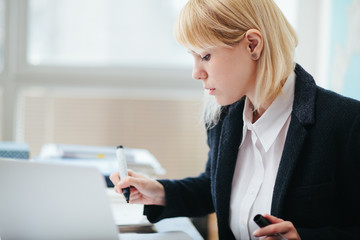 Woman in office working, writing