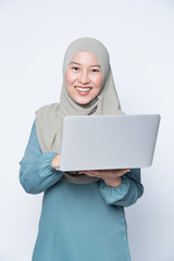 Wall Mural - Muslim woman using a laptop with facial expression.