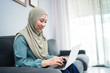 © Faiz - Female muslim using laptop at home environment.