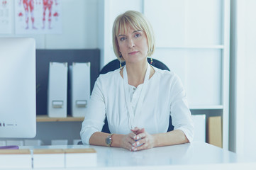 Portrait of young woman doctor in white coat at computer