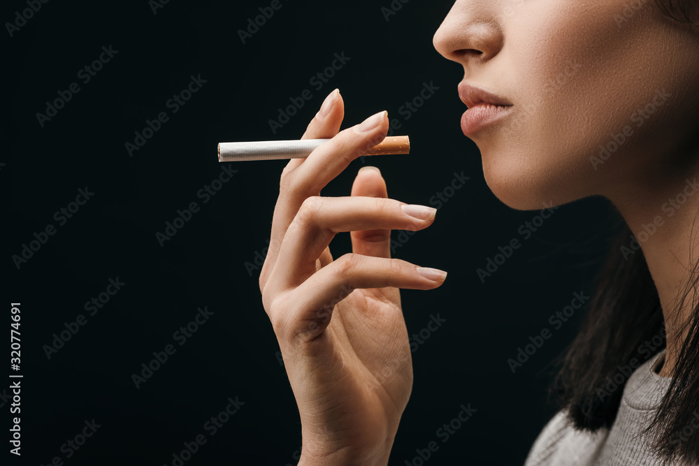 how to hold a cigarette like a woman Side view of woman holding cigarette isolated on black Stock Photo