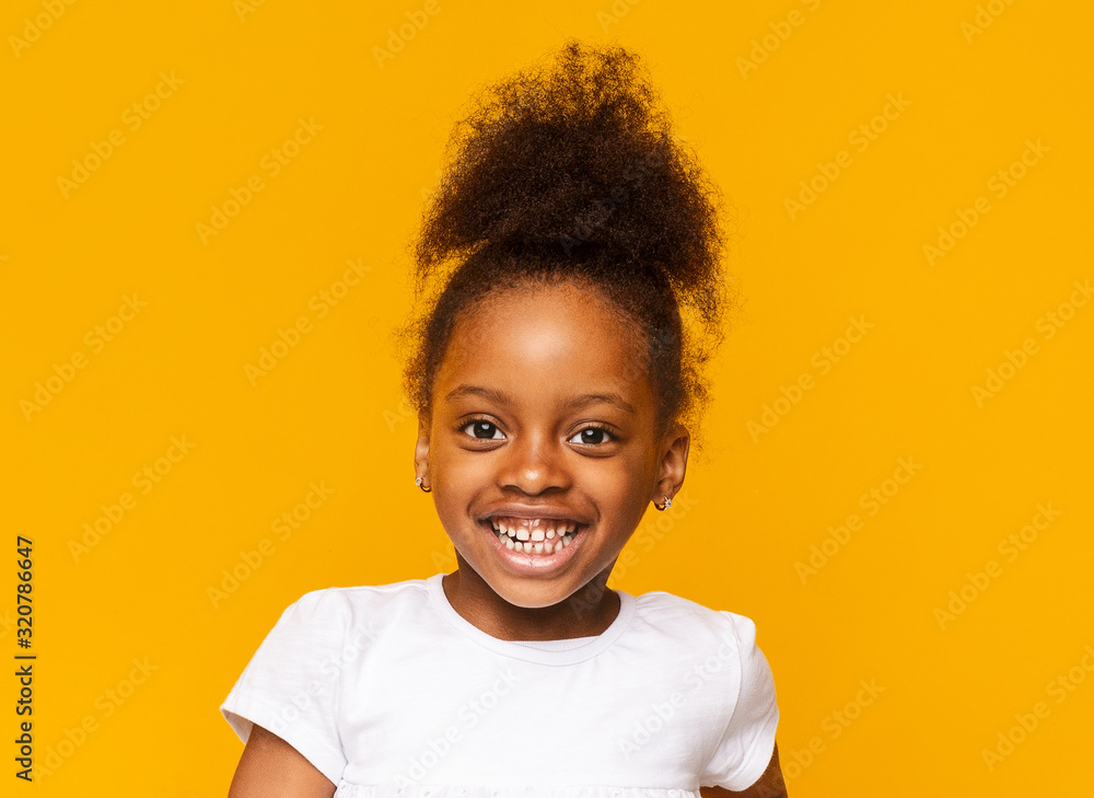 Portrait of african little girl smiling over yellow background - obrazy, fototapety, plakaty 