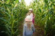 © MNStudio - Two cute young girls having fun in a corn maze field during autumn season. Games and entertainment during harvest time.
