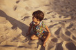 © EZ PHOTOS - Toddler playing in a sand dune