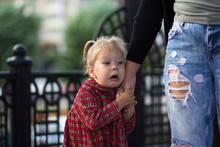 Funny And Scared Face Of The Caucasian Child Of Two Years Old Holding Mother Hand