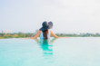 © siraphol - Portrait beautiful young asian woman happy smile relax around outdoor swimming pool in hotel resort