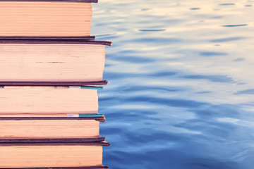 Sticker - a stack of books. ON WATER BACKGROUND