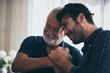 © chokniti - adult hipster son and old senior father stay for work at home, two generations have a beard talking together and relaxing with smile, happy enjoy living to isolation quarantine at home, Father's Day