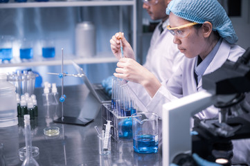 Wall Mural - in a modern laboratory scientists team conduct experiments, consisting of glassware test tubes and m