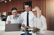 © Flamingo Images - Smiling young businesspeople working at a table in an office