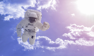 Wall Mural - creative concept of happy astronaut fly high in the sky with clouds, relax chill and dream idea elem