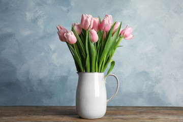 Poster - Beautiful pink spring tulips in vase on wooden table