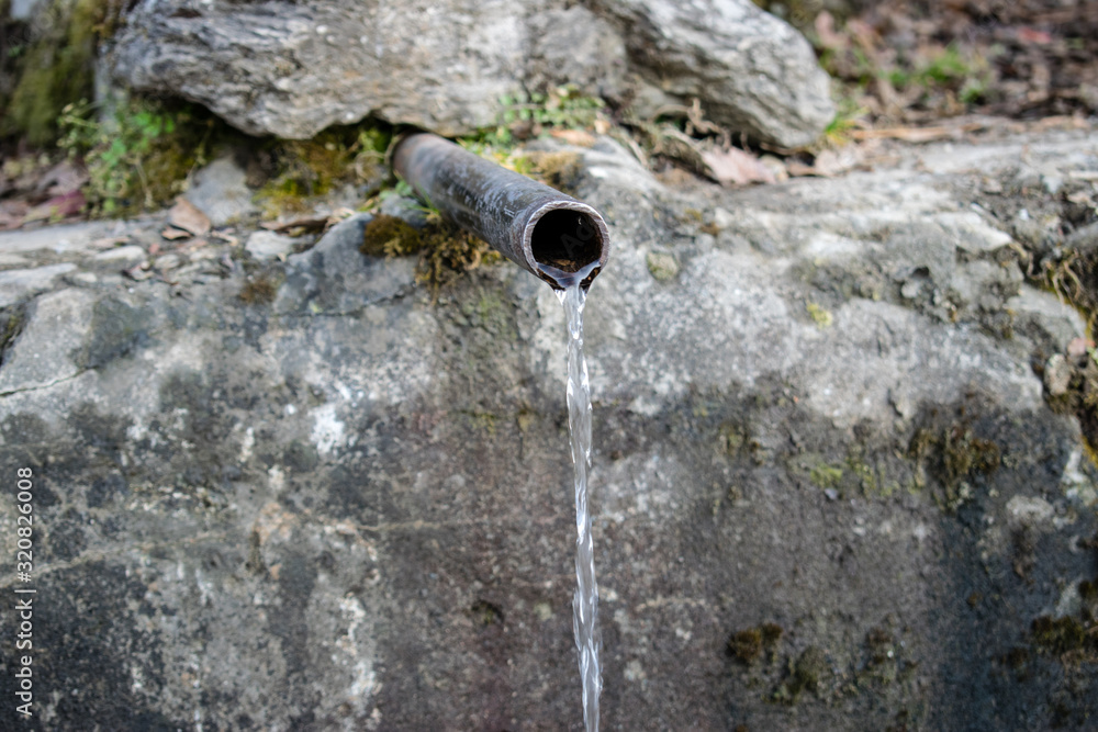 An old and ancient water tap flowing continuously deep inside the ...