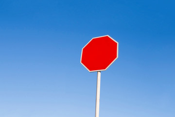 A red forbidding sign against a blue sky.