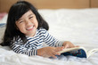 © Asada - Asian cute child girl is reading the book at home. Education concept.