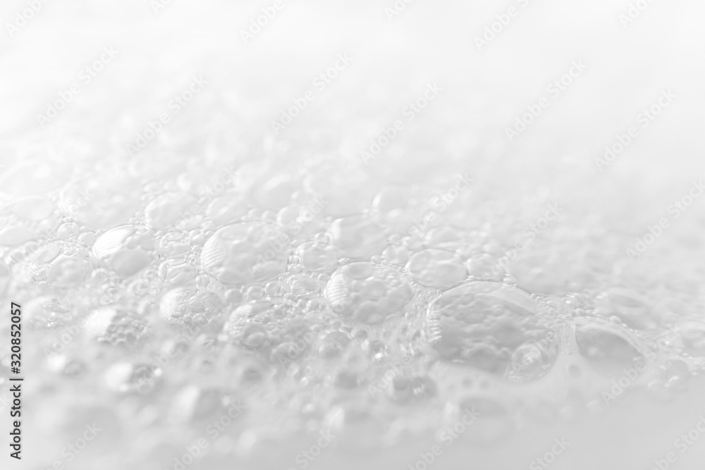 Close-up foam bubbles with selective focus from soap, shampoo or cleanser on white background. Macro - obrazy, fototapety, plakaty 