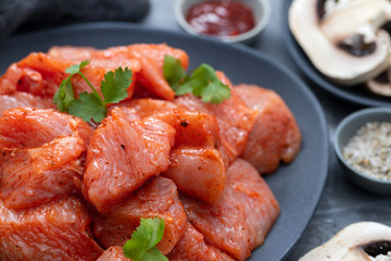 Sticker - raw meat with spices on dark dish on ceramic background