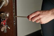 Closeup Of A Professional Locksmith Installing Or Repairing A New Deadbolt Lock On A House Exterior Door With The Inside Internal Parts Of The Lock Visible