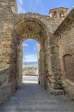 Fototapeta Uliczki - Ancient village with passage under archway in Tuscany