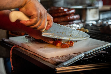 man cooking tacos cutting with steak and sausage knife to put in tortilla mexican food