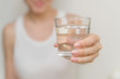 © Асель Иржанова - healthy beautiful young woman holding a glass of water. clean drinking water in a clear glass in your hands