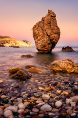 Wall Mural - Aphrodite's Rock or Petra tou Romiou, the birthplace of Goddness Aphrodite, Paphos, Cyprus. Amazing sunset seascape with stunning rock, vertical travel background, popular tourist location
