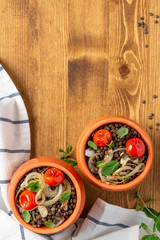 Sticker - Cooked green lentils with tomatoes, onions and mint in pots on a wooden background, top view, copy space. Vegan and vegetarian food, Mediterranean cuisine.