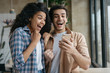 © ARUTA Images - Happy emotional couple celebration success. Excited friends using smartphone, playing video games. Portrait of overjoyed online lottery winners holding mobile phone, looking at digital screen