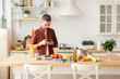 © deniskomarov - Man preparing dinner look for recipe at phone