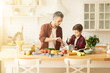 © deniskomarov - Handsome man and boy cooking together on kitchen