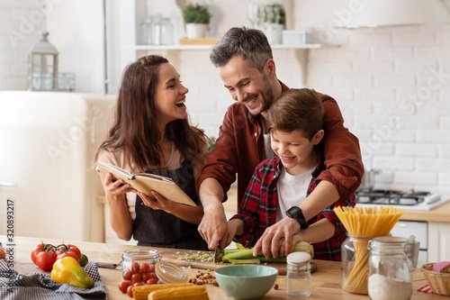 Happy family laughing loud and cooking on kitchen Tableau sur Toile