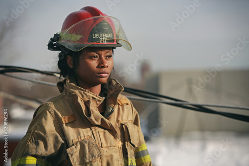 Fotografie, Obraz Women Firefighter with red helmet standing outside