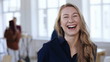 © vadim_key - Happy blonde business woman in formal clothes posing, laughing and smiling cheerfully at trendy modern office workplace.