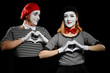 © yuriygolub - Mimes makes heart shapes with hands. Man and woman as mime artists