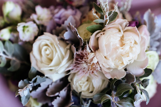 rich bunch of pink peonies and lilac eustoma roses flowers, green leaf in glass vase. fresh spring b