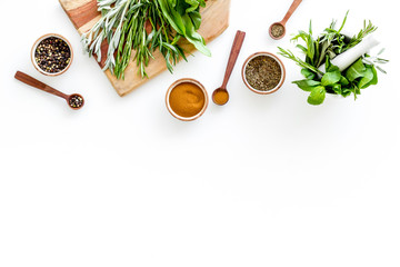 Wall Mural - Making spices. Herbs in motar and dry flavorings on white table top-down copy space