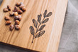 Wooden сutting board engraved with botanical pictures, wood board on linen surface 