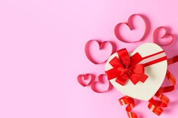 Heart gift box and heart red ribbon on pink background,