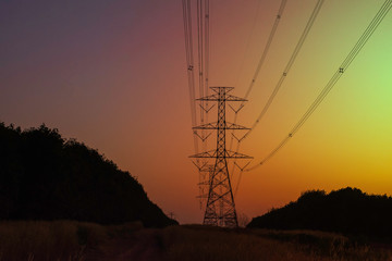 Electricity pole with silhouette sunset sky, Electricity pylon with shadow of tree in dawn time, Electricity power transmission line on sunset with copy space, Electricity pylon on orange sky