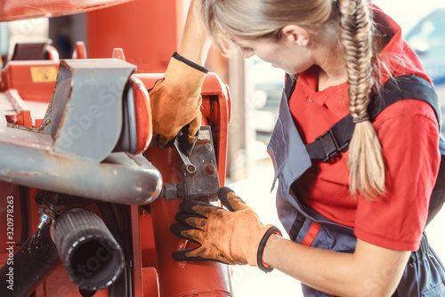 Fotografía Woman machinist working with wrench of a farm machine