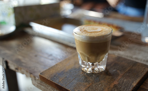 Photographie Close up hot coffee latte in transparent glass on timber table