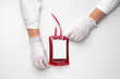 Hands of doctor with blood pack for transfusion on white background