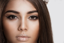 Trendy Style Makeup. Closeup Portrait Cropped Image Brunette Woman Face With Beautiful Shiny Eye Makeup Lips On White Grey Background Wall. Dark Skin Beauty Queen Thick Eye Brows Brown Hair Contouring