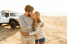 Loving Couple Outdoors At Beach Near Car Hugging.