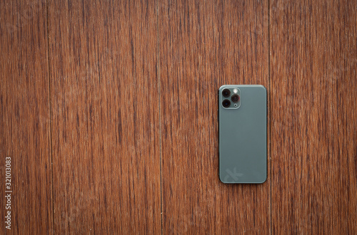 Fotografía back smartphone on wooden desktop. Top view