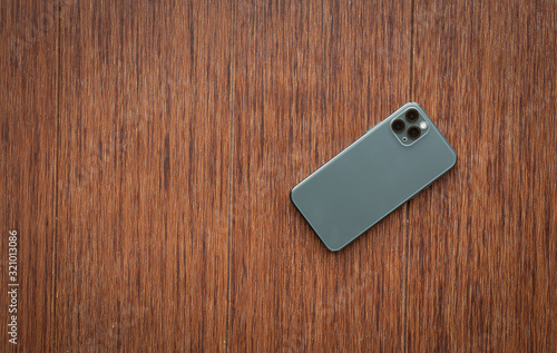 Fotomural back smartphone on wooden desktop. Top view