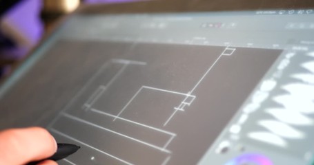 Wall Mural - an architect drafting out blueprints or concept art for a building project on a digital graphic tabl