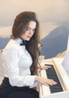 Young beautiful woman playing the piano at home