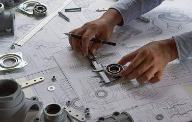 Fototapete - Engineer technician designing drawings mechanical parts engineering Engine.manufacturing factory Industry Industrial work project blueprints measuring bearings caliper tools
