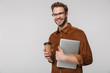 © Drobot Dean - Portrait of cheerful young man posing with laptop and paper cup